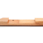 A close-up of a light natural wood block or tool with a small circular hole, shown against a plain white background.